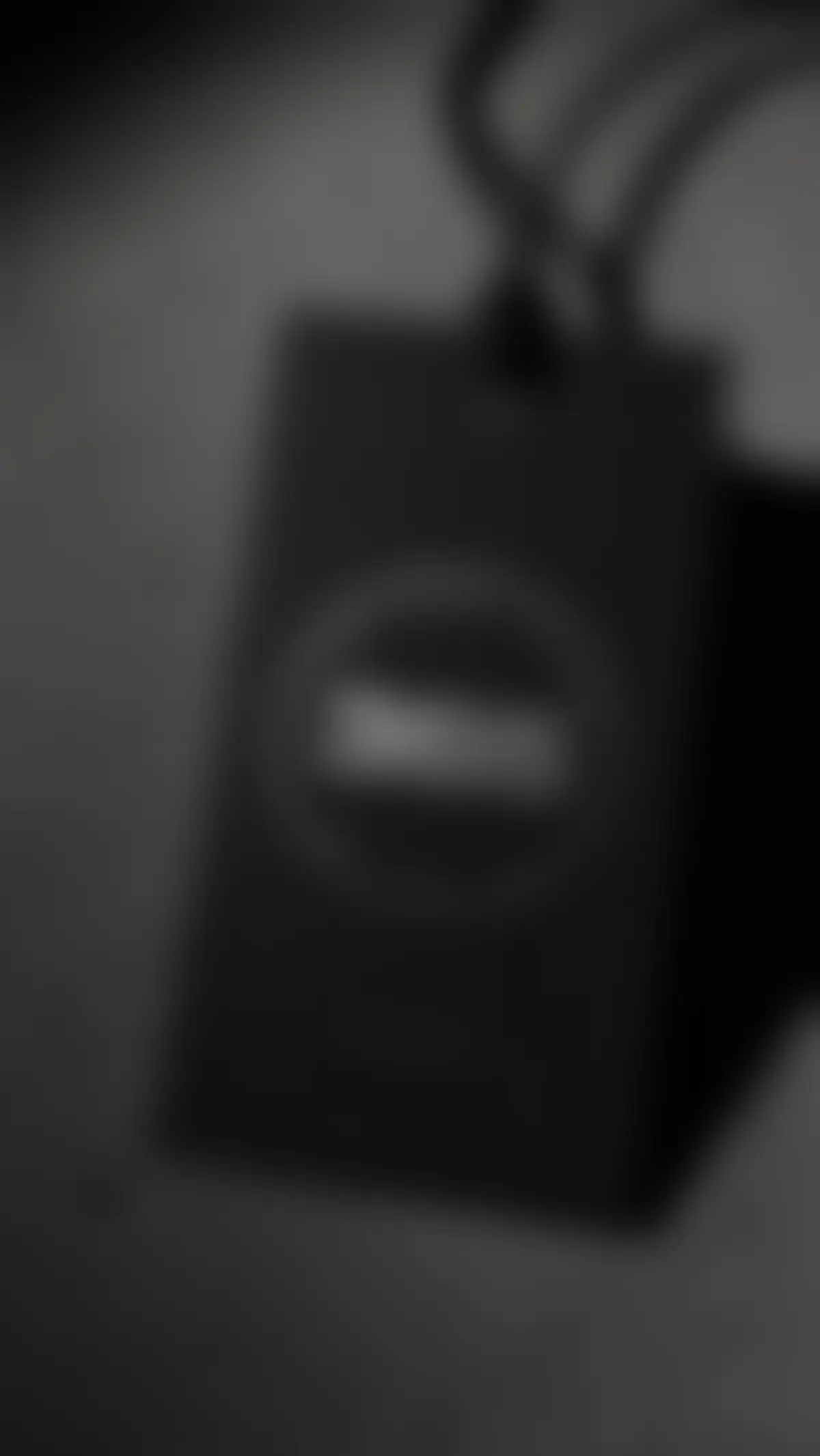 Matte black hangtag with silver foil 365 seal on waxed cotton string